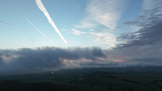 Time-lapse of moving clouds over rural area during sunset
