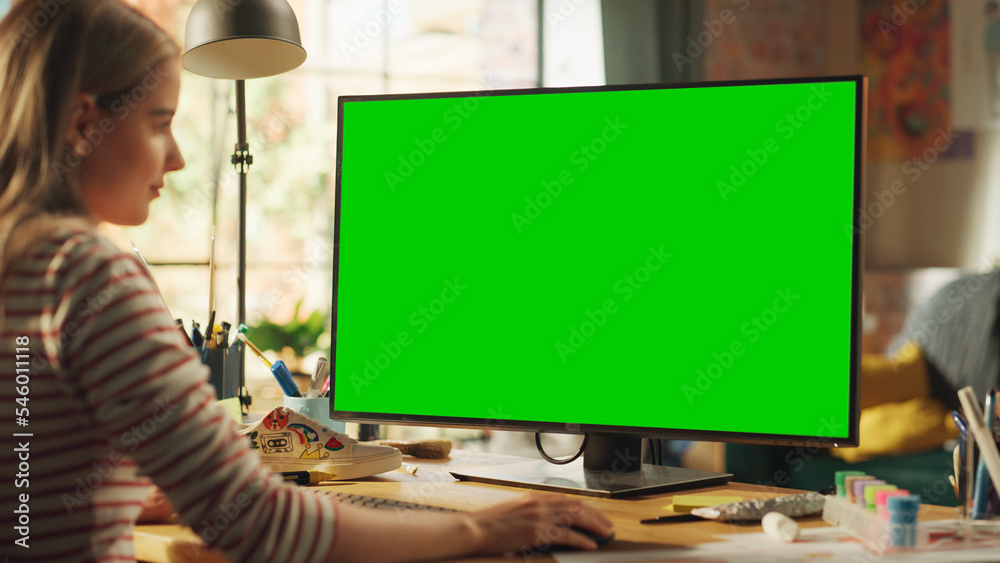 Poster blonde female creator modelling on desktop computer with green screen chroma key on display. freelan
