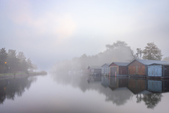 Bootshäuser im Nebel am Morgen