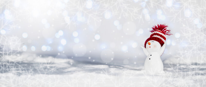 Happy snowman standing in winter christmas landscape. Merry christmas and happy new year greeting card. Funny snowman in hat on snowy background. Banner