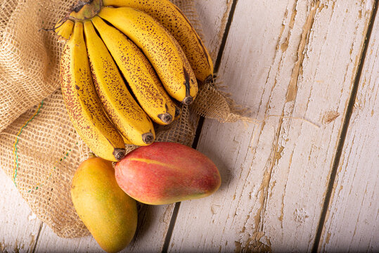 Ripe bananas and mangoes, details of a bunch of very ripe bananas and some mangoes, selective focus