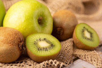 Green apple and kiwi, green apples and kiwi fruit laid on rustic wood with rustic fabric, selective focus