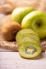 Green apple and kiwi, green apples and kiwi fruit laid on rustic wood with rustic fabric, selective focus