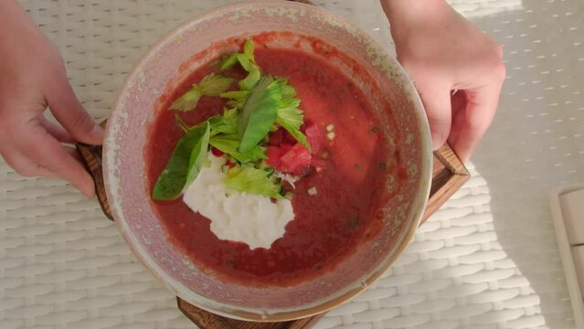 Serving gazpacho with stracciatella cheese in restaurant. Traditional dish of Spanish cuisine. 