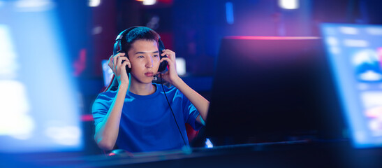 Concept banner cyber esport Korean. Beauty Young asian man pro gamer streamer playing in online video game, neon color soft focus