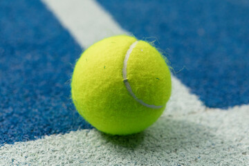 Tennis ball in a blue floor in a panel court