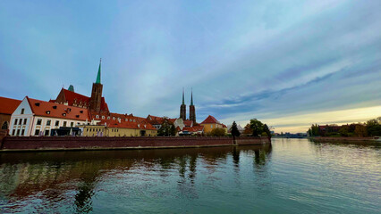 Fototapeta premium River in the city. Panorama of the town. The historic architecture of the old town. Historic buildings on the banks of the river. The center of the old town. Wroclaw, Poland.