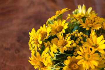Bouquet of bright different yellow flowers on a table	