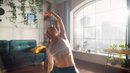 Loft Apartment Workout: Young Athletic Woman Exercising, Stretching and Practising Yoga in the Morning in Her Bright Sunny Home Living Room. Healthy Lifestyle, Fitness, Wellbeing and Mindfulness.