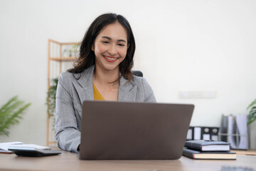 Portrait of an Asian young business Female working on a laptop computer in her workstation.Business people employee freelance online report marketing concept.