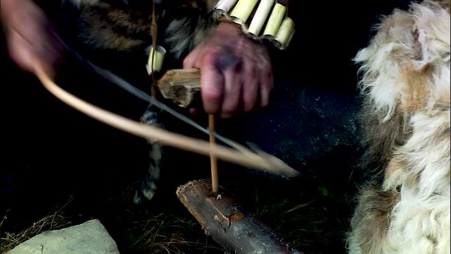 Ancient people make fire by rubbing one piece of wood against another. Tribe of primitive people.