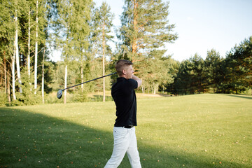 Male athlete plays golf on the field. Strong hit on the ball. High quality photo