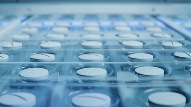 Close-up Shot of White Pills During Production and Packing Process on Modern Pharmaceutical Factory. Medical Drug Manufacturing.