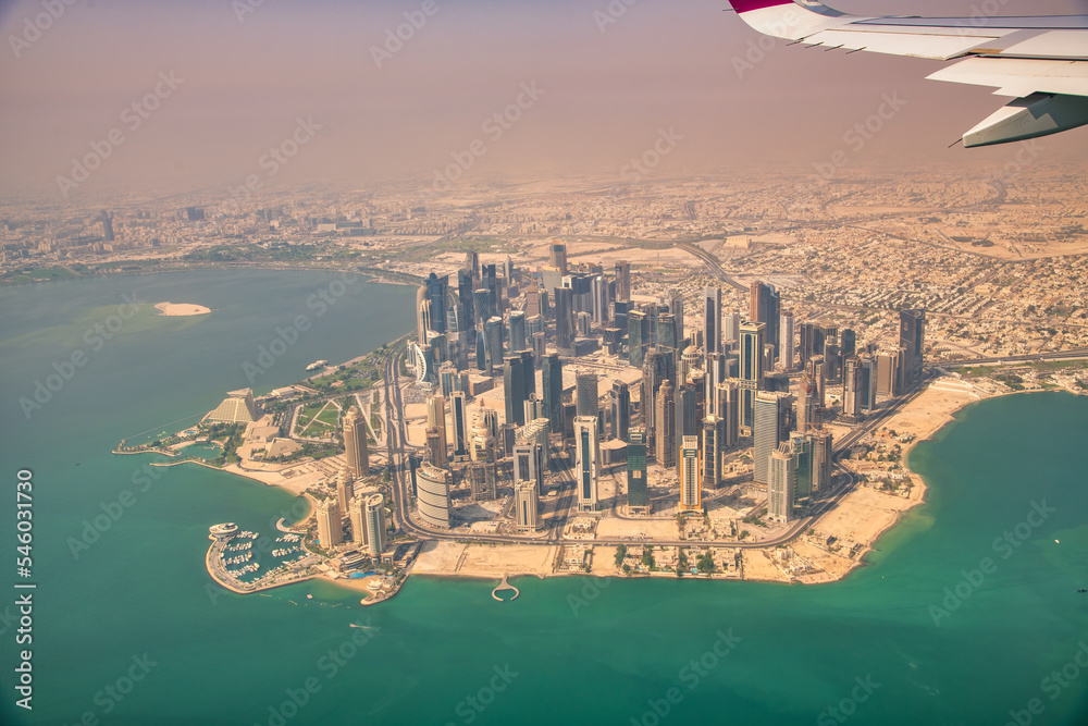 Poster Doha, Qatar - September 17, 2018: Aerial view of city skyline from a flying airplane over the Qatar capital