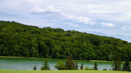 Field and Ostrzyckie Lake in a background. Nature of Wiezyca, Poland. © Jan