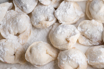 Fototapeta na wymiar Blinded dumplings from dough in flour