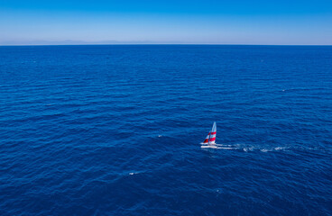 Aerial top view of sailing boat move turquoise sea. Concept summer water sport trip