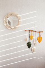 Macrame mirror and macrame leaves wall hanging in yellow, white, green and natural color on the wooden stick. Cotton rope decor macrame to make your room more cozy and unique.
