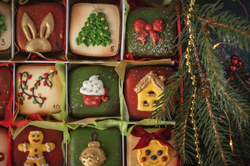 Delicious Christmas cookies set in a gift box. Advent calendar to count the days in anticipation of Christmas. Gingerbread cookies with festive red and green icing on the Christmas background - obrazy, fototapety, plakaty