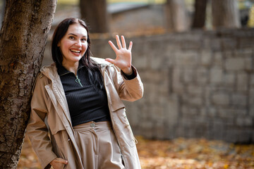 Attractive and stylish woman portrait in autumn season with trenchcoat. Sign and five tips cpncept with copy space.