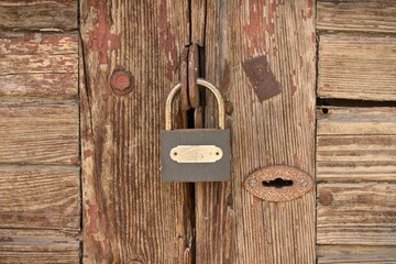 Closeup shot of a padlock on an old wooden door