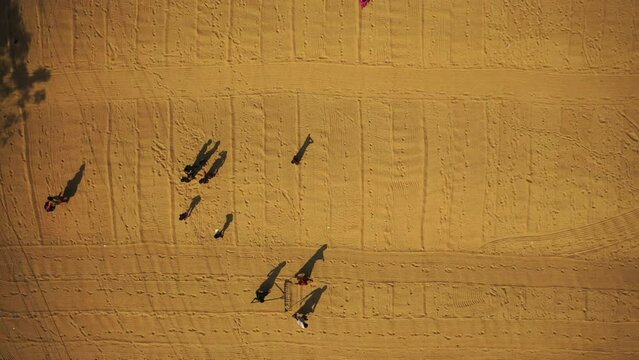Aerial view of farmers working in a field drying rice on a rice field in Dhamrai, Dhaka, Bangladesh.