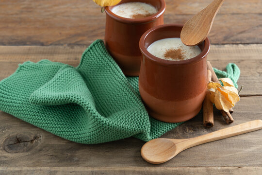 Bowls of rice pudding and cinnamon on a wooden background. Copy space.