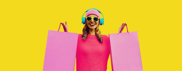 Portrait of stylish happy smiling young woman enjoying listening to music in headphones with...