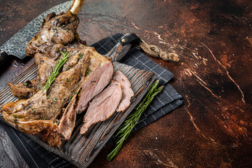 Slow Cooked grilled lamb mutton shoulder meat with herbs and spices on wooden board. Dark...