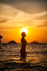 Fototapeta na wymiar woman silhouette in the sea at sunset