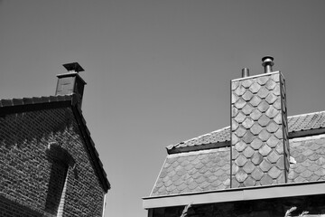 Small town with beautiful old houses with brick walls and tile roofs under a clear sky in grayscale