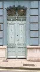 Puerta de madera color azul palo con adornos esculpidos
