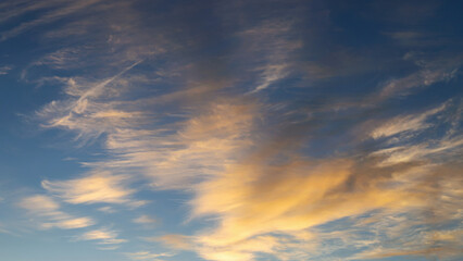 Obraz premium blue sky with golden clouds beautifully illuminated by the sun as a natural background