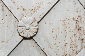 Round iron decoration on the metal door of christian church or cathedral. Detail of door with...