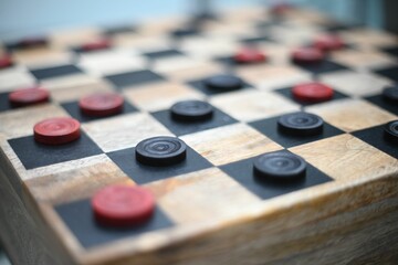 Closeup shot of a handmade wood checkers game with red and black squares