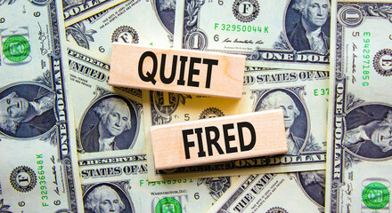 Quiet fired symbol. Concept words Quiet fired on wooden blocks. Beautiful background from dollar bills. Business and quiet fired concept. Copy space.