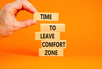 Leave comfort zone symbol. Concept words Time to leave comfort zone on wooden blocks Businessman hand. Beautiful orange table orange background. Business time to leave comfort zone concept. Copy space