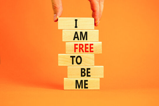 I am free to be me symbol. Concept words I am free to be me on wooden blocks on a beautiful orange table orange background. Businessman hand. Business i am free to be me concept.