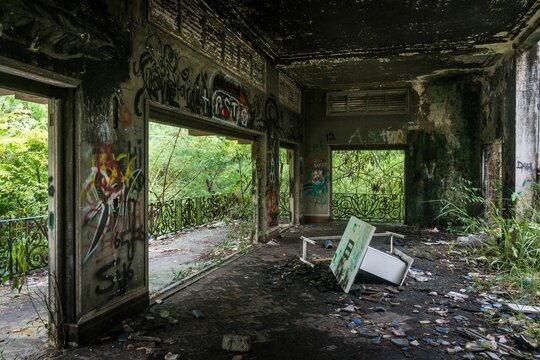 Abandoned building with graffiti art walls and a broken table in a natural setting