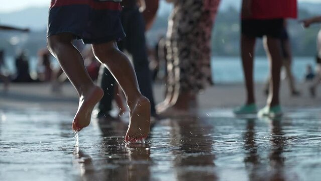 Wet happy child feet and legs jumping of joy splashing water in slow motion 120fps