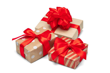 Close up set of three gift boxes wrapped in craft paper and decorated with satin ribbon bows, isolated on white background