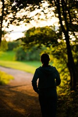 Young woman in sportswear running on a forest path during the daytime