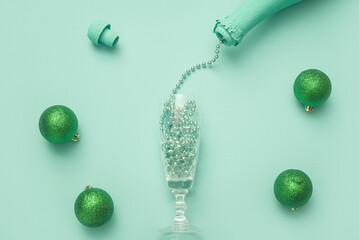 New Year concept. Open bottle in champagne color cyan with jewelry decorations and Christmas balls. Design idea.