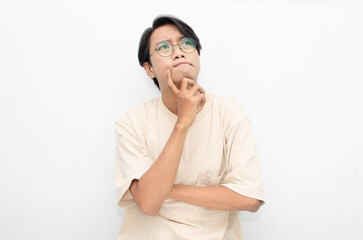 Thoughtful confused asian man thinking and wondering to choose something isolated over white background. man feeling uncertain and unsure.