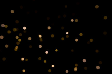 Abstract golden yellow circular blurred bokeh lights for a festive background. Defocused image.