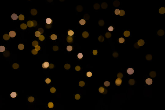 Abstract golden yellow circular blurred bokeh lights for a festive background. Defocused image.