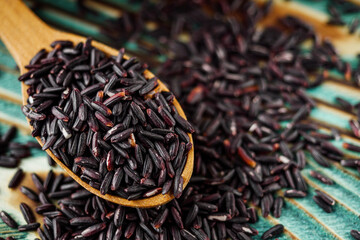 raw fresh black rice on wooden rustic background