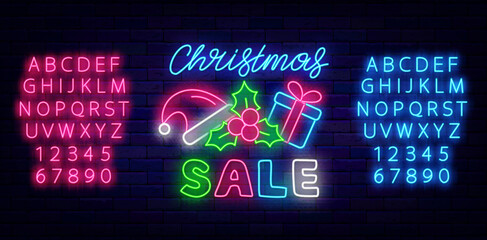 Christmas sale neon signboard on brick wall. Shopping emblem. Santa Claus hat, berry and present. Vector illustration