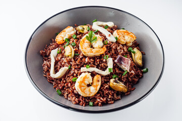 delicious red rice with shrimps and seafood on a white background