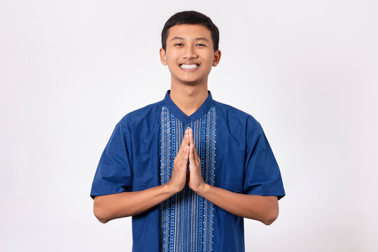 Smiling Asian muslim man happy celebrating Eid Al-Fitr isolated white background. Celebrate Ramadan Holy month in Islam